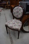 A reproduction bedroom chair having floral upholstery