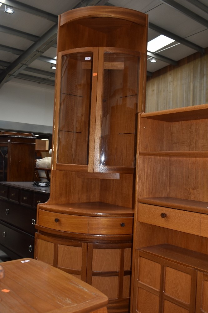 A vintage Nathan corner unit having upper shelf over glazed display section frieze drawer and