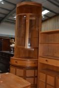 A vintage Nathan corner unit having upper shelf over glazed display section frieze drawer and