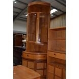 A vintage Nathan corner unit having upper shelf over glazed display section frieze drawer and