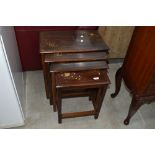 An Oriental style hardwood nest of three table with brass inlay