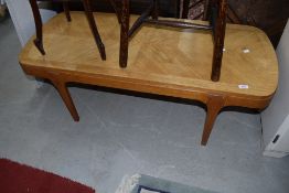 A mid century oak coffee table having quarter panel top