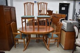 A modern kitchen table in light stain having six (four plus two) chairs
