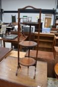 An antique three tier folding cake stand in oak