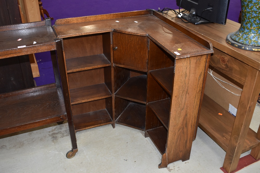 An early 20th Century oak corner bookshelf of small proportions, having integral smokers cabinet,