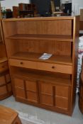 A vintage Nathan bookshelf, with central drawer section and double cupboards to base, dimensions