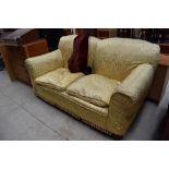 An early 20th Century dropend settee having later damask style loose cover, width approx. 183cm