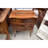 A reproduction yew wood serpentine bedside or similar chest of drawers, with winged top