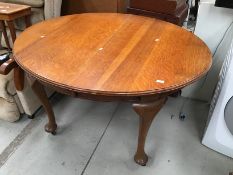 An early 20th Century golden oak oval windout dining table on heavy cabriole legs, length closed