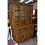 A top quality modern solid golden oak dresser, having open shelves flanked by displays over three