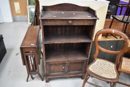 An oak book shelf having carved detailing and under drawer