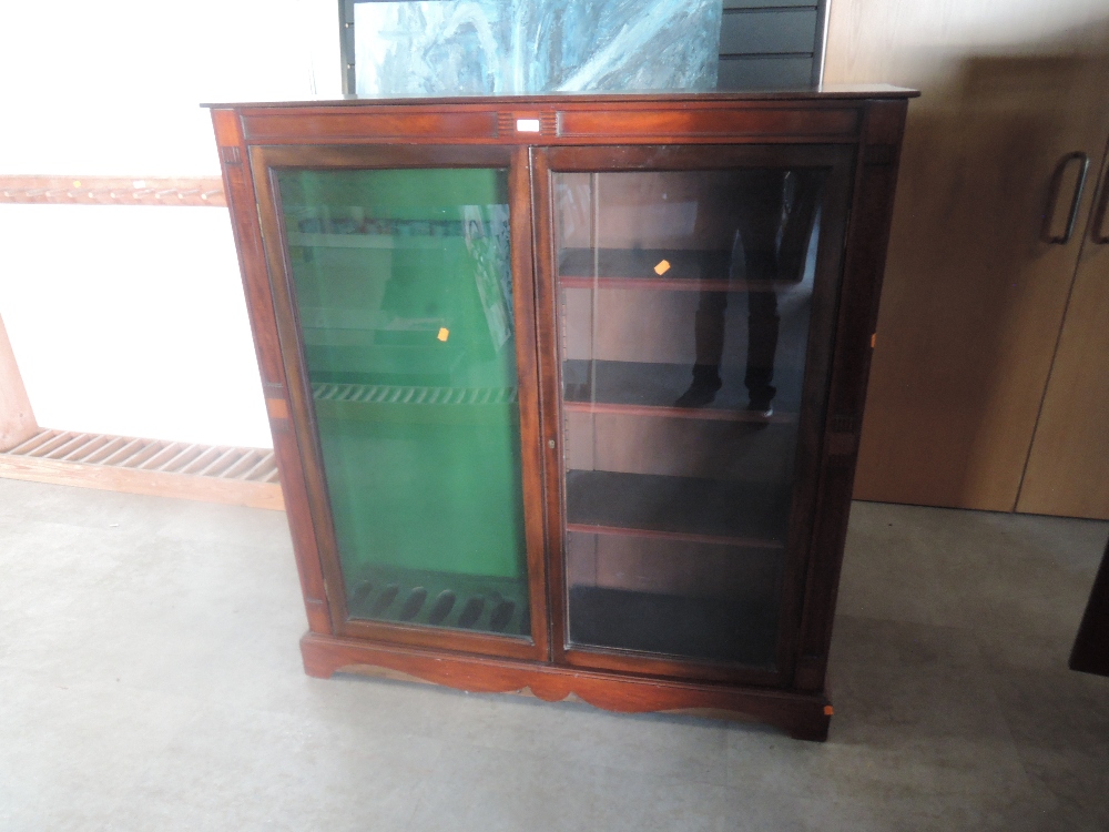 A mahogany and glazed free standing upright Gun Case, spaces for 7 guns and four shelves width