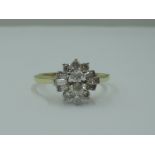A lady's dress ring having a diamond cluster with central oval diamond surrounded by baguette and