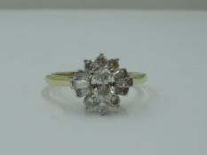 A lady's dress ring having a diamond cluster with central oval diamond surrounded by baguette and