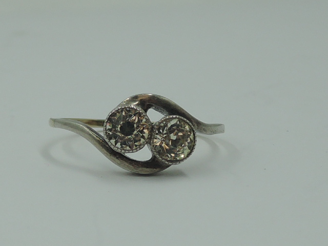 A lady's dress ring having a duo of spinels in collared mounts to cross over shoulders on a yellow