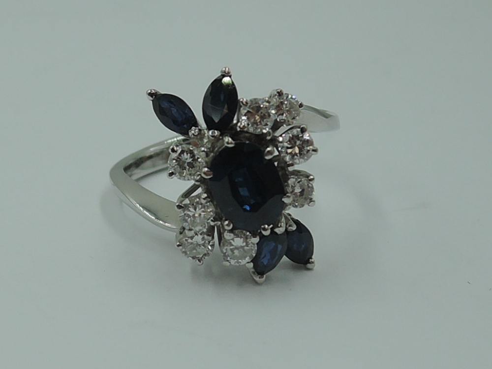 A lady's dress ring having a central sapphire, approx 0.75ct surrounded by four marquise cut