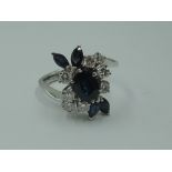 A lady's dress ring having a central sapphire, approx 0.75ct surrounded by four marquise cut