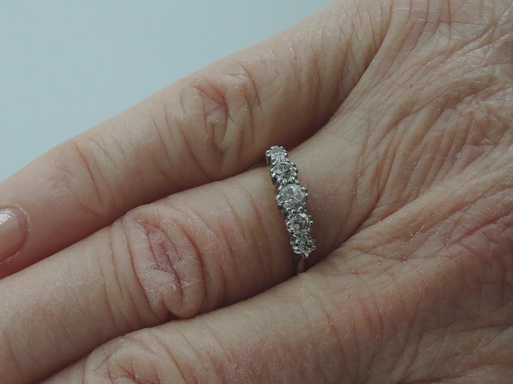 A lady's dress ring having five graduated diamonds in a claw set raised mount on a yellow metal loop - Image 2 of 2