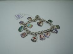 A silver bracelet with padlock clasp having eleven (& two loose) white metal shields stamped silver,