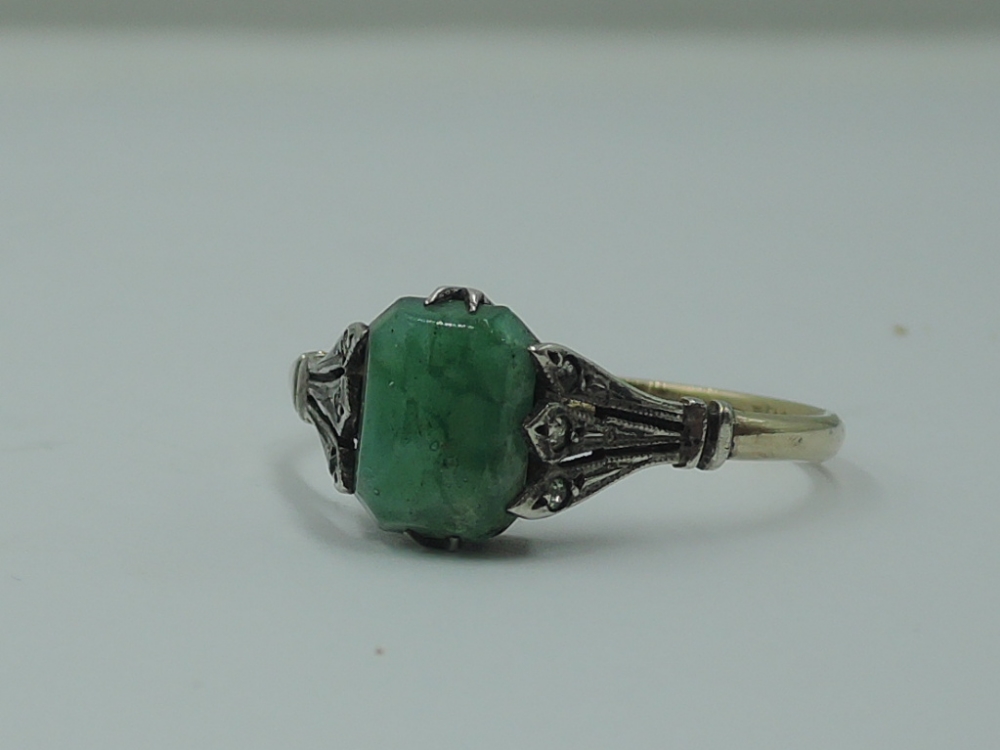 A lady's dress ring having a rectangular jadeite style stone in a claw set basket mount with