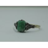 A lady's dress ring having a rectangular jadeite style stone in a claw set basket mount with