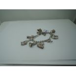 A silver charm bracelet with padlock clasp having eight white metal charms including camel, emu,