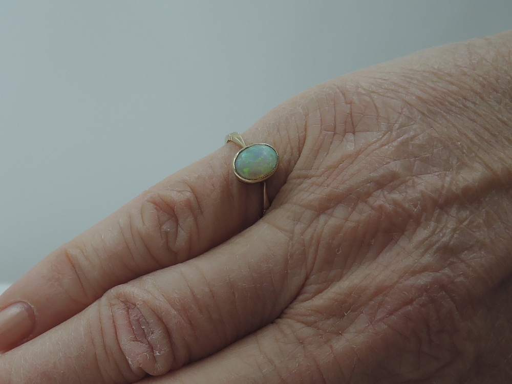 A lady's dress ring having an oval opal in a collared mount on a rose gold loop stamped 9ct, size I - Image 2 of 2