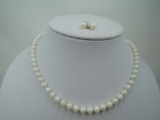 A string of cultured pearls of even form having yellow metal clasp, approx 16' and a pair of matched