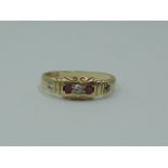 A lady's 18ct gold band ring having rubies and diamonds inset in a moulded mount, size N