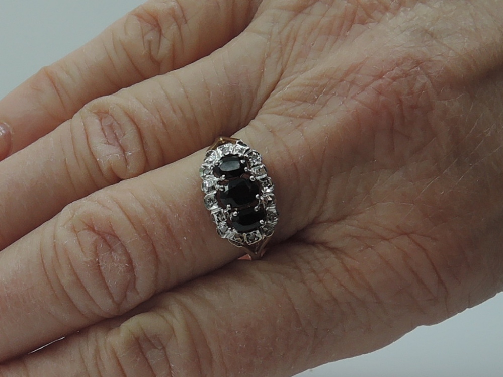 A lady's dress ring having a trio of oval sapphires within a diamond chip set illusionary surround - Image 2 of 2