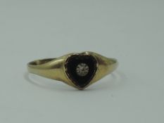 A 9ct gold signet ring having a heart shaped onyx panel with diamond chip inset, size R & approx 1.