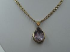 A 9ct gold fancy link chain with a tear drop style amethyst pendant in a yellow metal mount, no