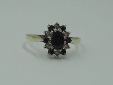 A lady's dress ring having an oval sapphire and diamond chip cluster on a 9ct gold loop, size N