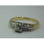 A lady's dress ring having a diamond chip solitaire in a raised illusionery setting to moulded
