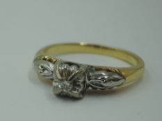 A lady's dress ring having a diamond chip solitaire in a raised illusionery setting to moulded