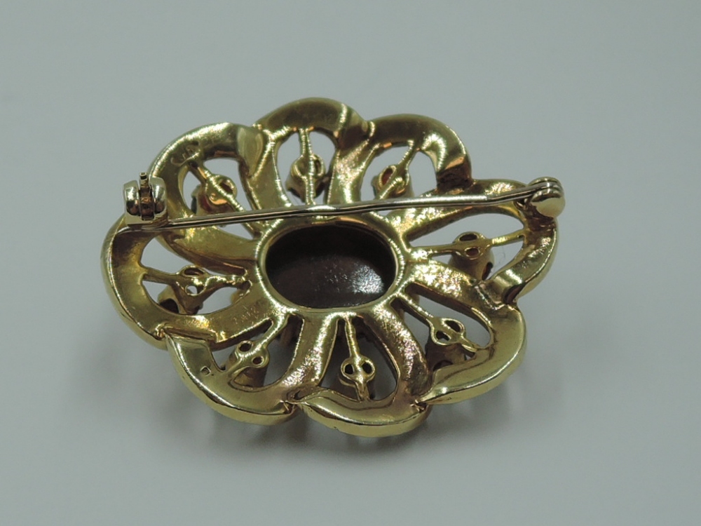 A yellow metal brooch having central garnet cabouchon within an open surround of seed pearls and - Image 2 of 2