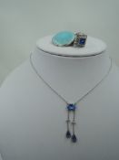 A lady's Art Deco style dress ring having a blue paste stone within a clear paste square border in a