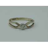 A lady's diamond solitaire dress ring, approx 0.128ct in a claw set mount to open shoulders on a 9ct