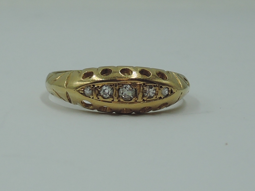 A lady's dress ring having five graduated diamond chips in a gallery mount on an 18ct gold loop,