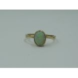 A lady's dress ring having an oval opal in a collared mount on a rose gold loop stamped 9ct, size I