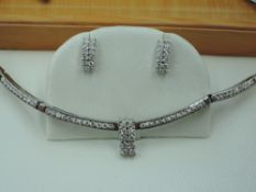 A white metal articulated bar link necklace having four channel set diamond bars with a central