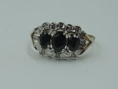 A lady's dress ring having a trio of oval sapphires within a diamond chip set illusionary surround