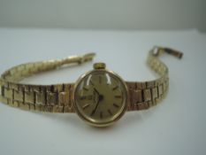 A lady's 9ct gold Omega wrist watch having a baton numeral dial to champagne face in a gold case