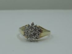 A lady's dress ring having a diamond chip triple cluster in a stepped mount to shaped shoulders on a