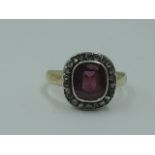A lady's dress ring having a central pink stone possibly tourmaline in a collared mount with diamond