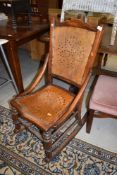 A folk art styled rocking chair having turned oak frame with ply board back