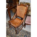 A folk art styled rocking chair having turned oak frame with ply board back