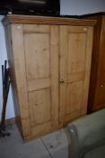 A wardrobe or cloak cupboard in stripped pine H154cm x W108cm x D45cm