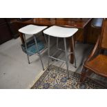 A pair of modern bar or kitchen stools with white vinyl tops