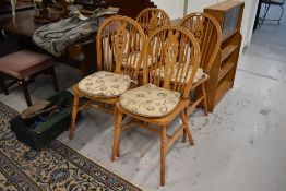 A set of four beech wheelback dining chairs